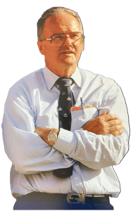 Lamar Hunt stands with his arms folded.